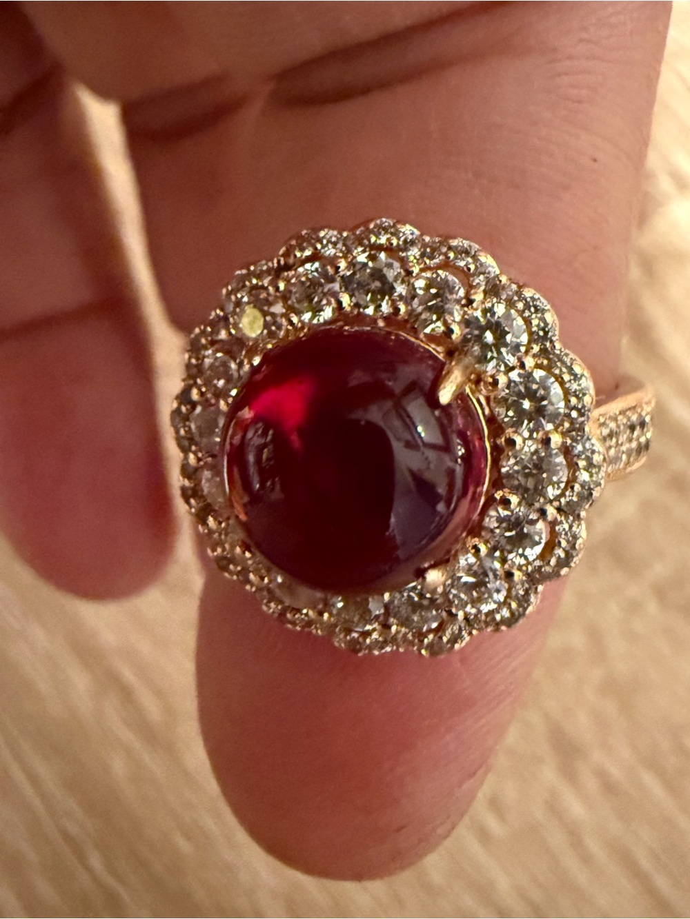 Gold Ring with Deep Red Cabochon Center and Pave Halo